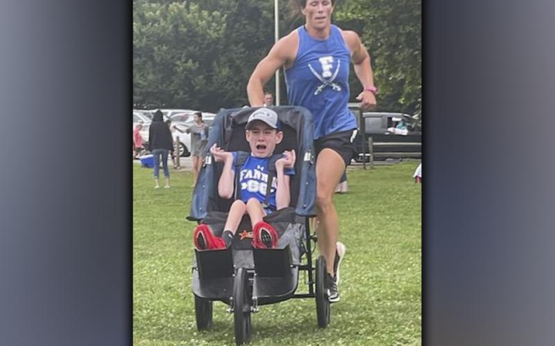 Brady Smith cries out in joy as he and his mother, Ashley Herendon, race to the finish line during a recent Fannin County High School Cross Country meet.