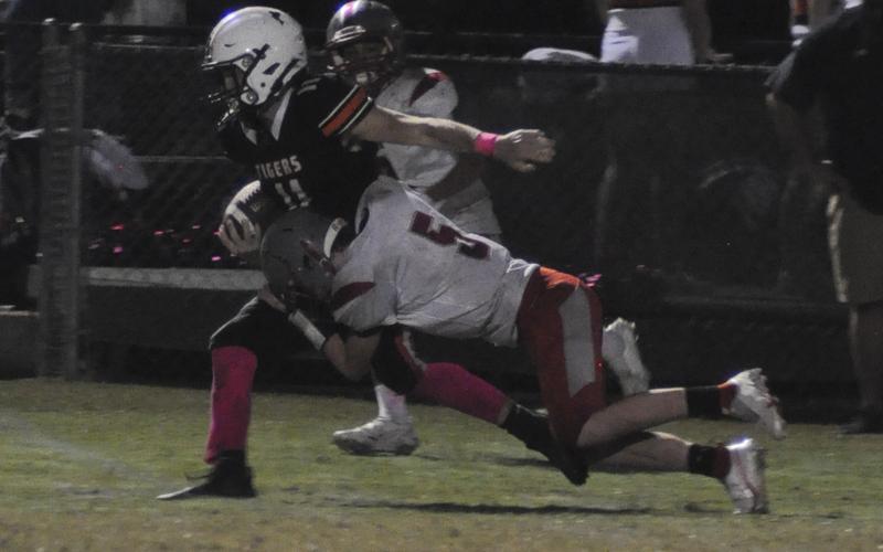 Isaac Deal (5) wraps up a Tiger ball carrier during the Cougars game against Meigs County Friday, October 8.
