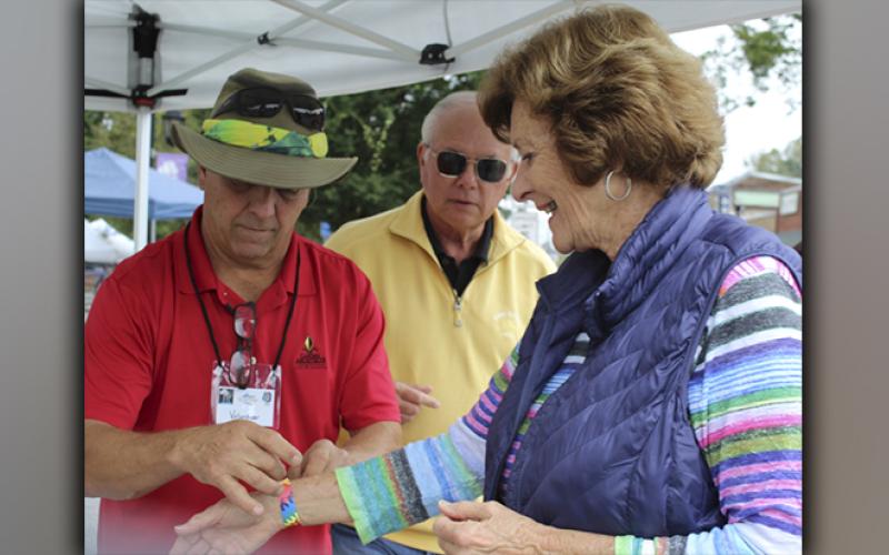 Greg Arnold, with the Blue Ridge Business Association, welcomes B.J. Martin, of Blue Ridge, to the Arts in the Park weekend Saturday, October 9. Also shown, waiting in line is David Mulder.