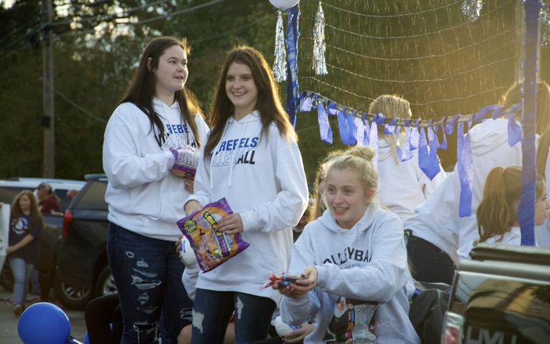 Fannin County Lady Rebels volleyball players Aubree McClure, Bailee Stiles and Ava Queen, from left, throw out candy to a crowd lined along East Main Street in Blue Ridge for a Homecoming Parade Thursday, October 21.