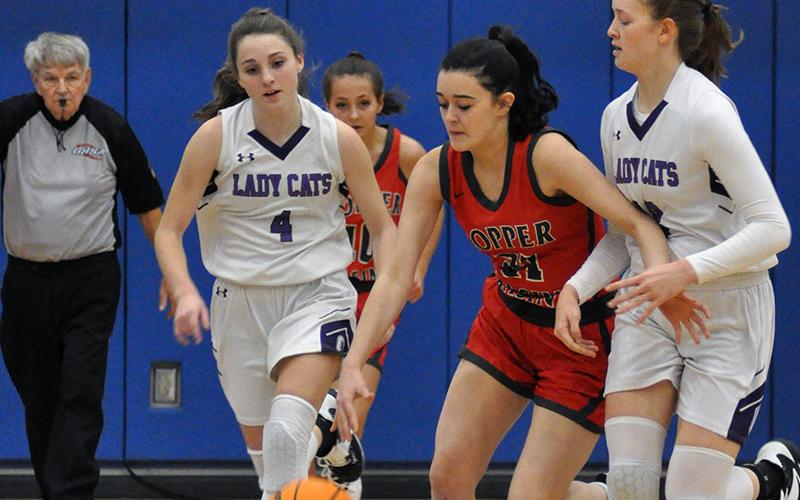 Lady Cougar Sarah Collis dribbles past two Lady Cat defenders in Copper Basin’s matchup with Gilmer County Tuesday, November 23.
