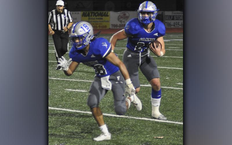 Austin Garland (18) leads the way for Seth Reece (23) in recent action for the Fannin County Rebel football team. Fannin topped Coosa 37-7 Friday, October 29, to remain undefeated in region play.