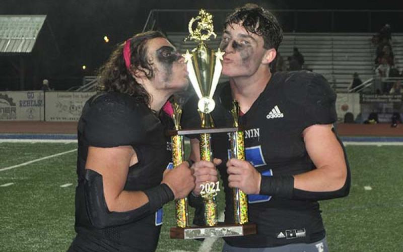 Andrew Waldrep (1), left, and Seth Reece (5) kiss the tropy they have worked for all season long. The Rebels claimed the region title Friday, November 5, after their 21-17 win over Dade County.