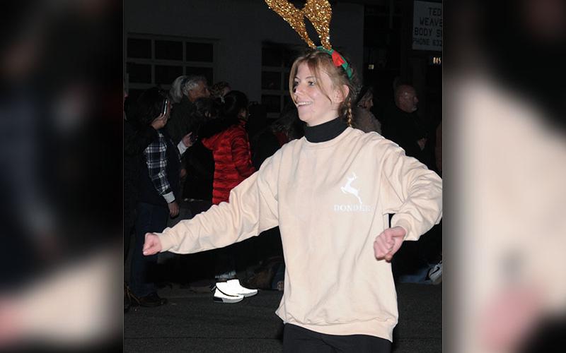 One of Santa’s reindeer dances down the street in the Light Up Blue Ridge Parade.