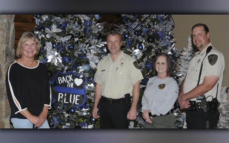Serenity in the Mountains owner Linda Cole, left, and her staff are once again hosting the Tour of Trees to benefit the Fannin County Shop With A Cop program. Shown with her in front of the “Back the Blue” tree are, from left, Sheriff Dane Kirby, coroner and Shop With a Cop Treasurer Becky Callihan, and deputy sheriff and Shop With a Cop committee member Jim Burrell.