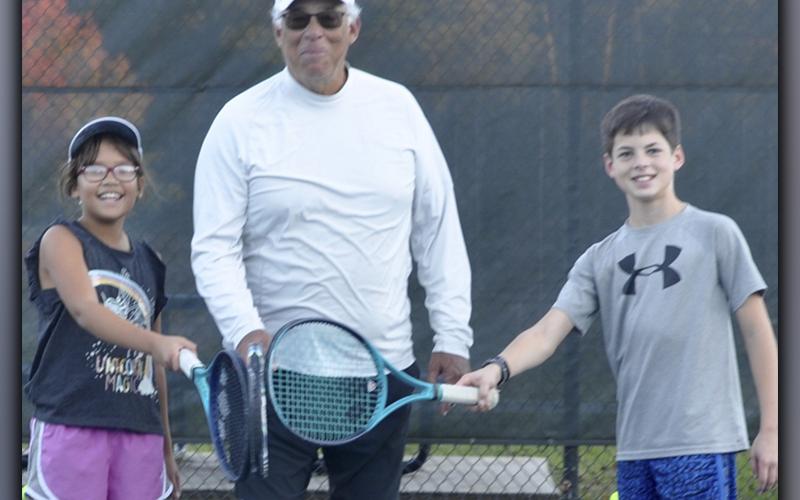 After their tennis lesson with Mel Locklear, from left, nine year old Ella Norris, Locklear, and 13 year old Garrett Pittman are all smiles at the Blue Ridge City Park Wednesday, November 10.