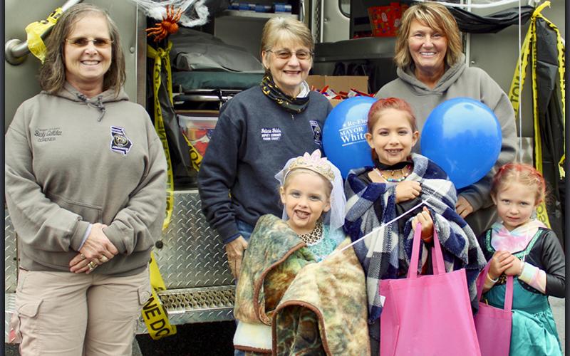 Despite a rainy evening, trick or treaters flocked to Blue Ridge’s Halloween Safe Zone Saturday, October 30. Shown are, from left, front row, Zoey, Chloe and Macy Lee; and back row, Fannin County Coroner Becky Callihan, Deputy Coroner Felicia Folds and Deputy Coroner Rebecca Hughson.