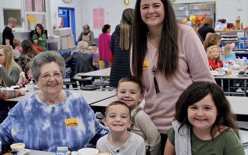Mary Chancey, left, and Brittney Pittman, standing, joined East Fannin Elementary School students, from left, Brantley Pittman, Mason Pittman and Mallory Pittman, for a Thanksgiving meal Tuesday, November 16.