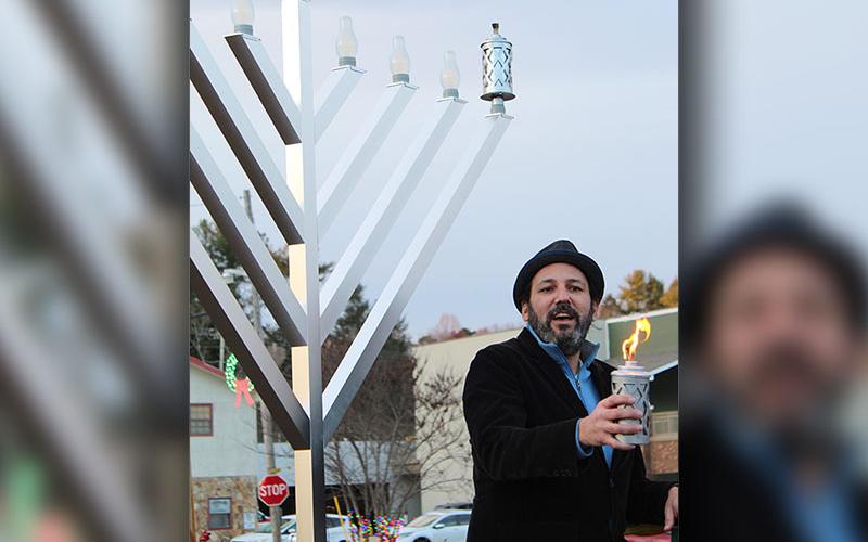 Charlie Chasen led the crowd in three blessings before and during the lighting of the first candle in observance of the first night of Hanukkah.