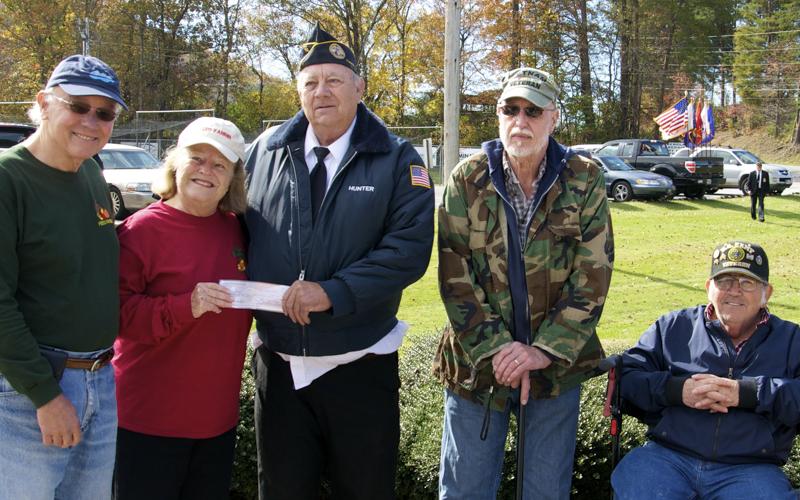Disabled American Veterans (DAV) Chapter 28 Commander Paul Hunter hands off a check to Feed Fannin volunteer Carol Martel to help the organization purchase turkeys and hams to be distributed to those in need for the holidays. Around them are, from left, Carlos Martel, Carol Martel, Hunter, DAV Chaplin Floyd Ballance, and DAV member Charles Spivey.