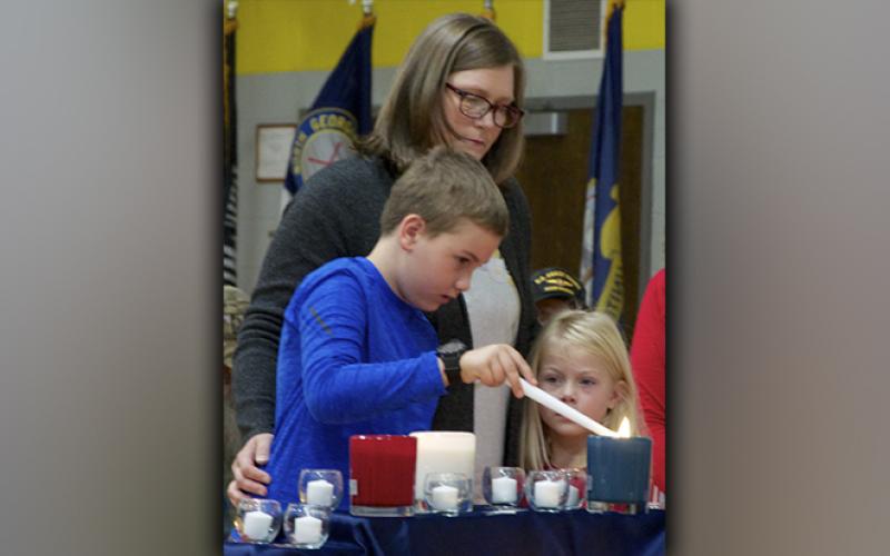 Connor Owens lights a blue candle in remembrance of the veterans who sacrificed it all during West Fannin Elementary School’s Veteran’s Day Program Friday, November 12. He is shown with mother Brooke and sister Reagan.