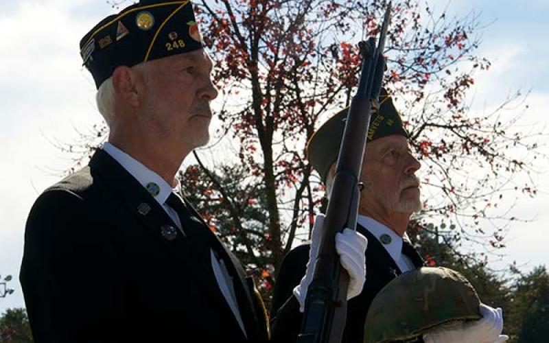 Veterans Steve Strickland, left, and Nick Wimberley present the rifle and helmet honoring the fallen military members during the Veterans Day Ceremony Saturday, November 6.