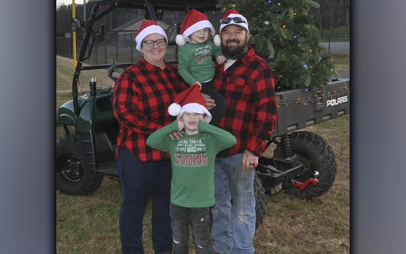 Families gathered at the Fannin County Recreation department fields Friday, December 3, to watch Santa Claus arrive by helicopter. Shown waiting patiently are, from left Elizabeth Bartlett, Creedence Bartlett and Ronald Bartlett holding Lauris Bartlett.
