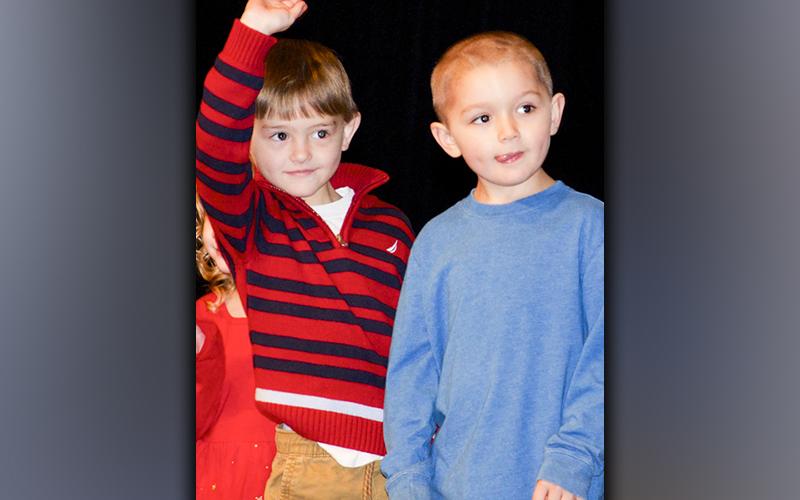 West Fannin Elementary School students Ezra Loudermilk, left, and Ayden Smith look out in the crowd for their family before performing during the White Christmas program.