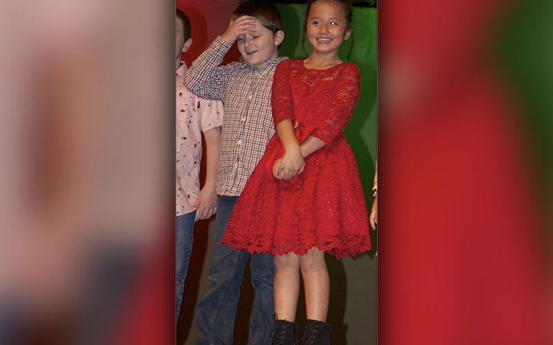 Third grade students Jameson Cloer and Sophia Ruiz, from left, shake off some nerves before singing “Rudolph the Red Nosed Reindeer” during East Fannin Elementary School’s “A Season of Joy” performances.
