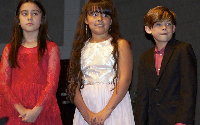Fifth grade students McKinley Lord, Lilliana Riuz and Adam King line up for their individual solo performances during East Fannin Elementary School’s “A Season of Joy” production.