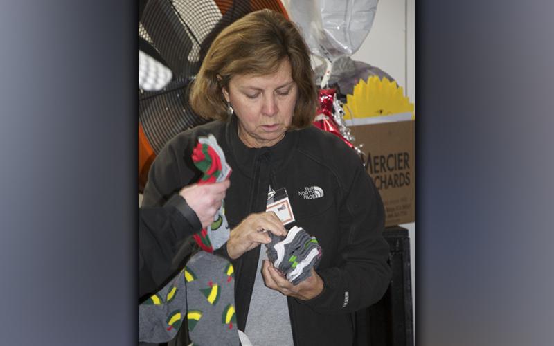 Snack in a Backpack volunteer Mary Langford arranges socks to be placed in the packs for local school children.