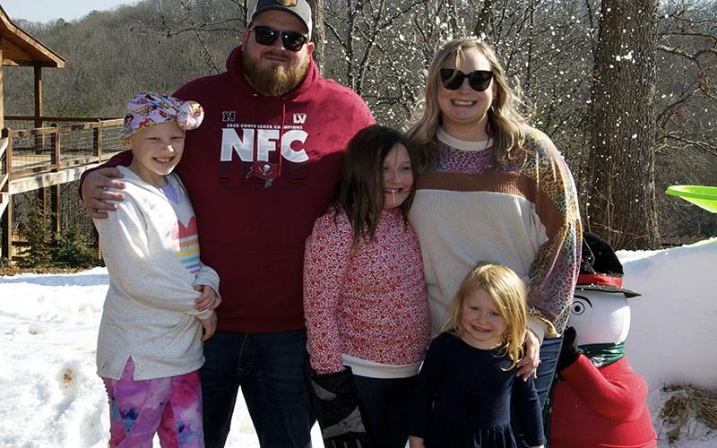 All the way from Florida, the Hutson family, Aubrey, Robert, Emmalyn, Lyndsi and Olivia, smile while standing in the “real fake snow” donated by Iceman and Atlanta Special FX.