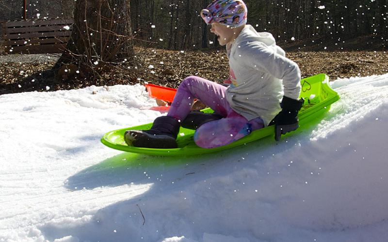 Aubrey Hutson slides down the makeshift hill topped with snow while at their rental cabin in Copperhill.