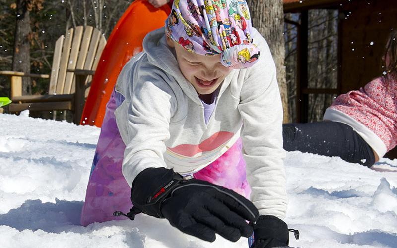 Aubrey Hutson is shown fulfilling her dream of playing in the snow while at a rental cabin in Copperhill that was donated.