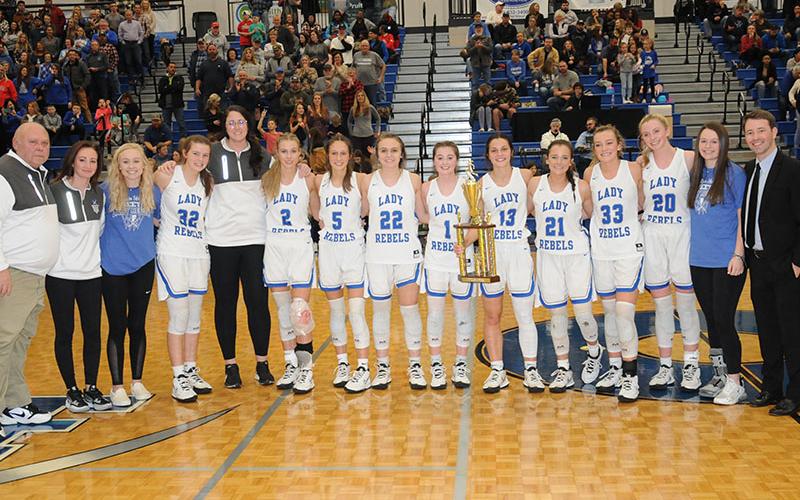 The Fannin County Lady Rebels proudly displayed the Region 7AA Championship trophy after their win over Chattooga High School Friday night. Shown following the team’s 24th victory this year are, from left, assistant coach Randy Hallmark, assistant coach Lacy Walden, Nicole Pittman, Macy Hawkins, assistant coach Megan Norton, Ellie Cook, Reigan O’Neal, Riley Reeves, Courtney Davis, Becca Ledford, Jenna Young, Reagan York, Ava Queen, Jayden Bailey and head coach Ryan Chastain.