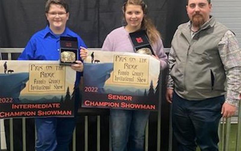Shown are competitors Roy Green and Meah Hobbs with Kam Childers, judge of the market hog show, to their right.