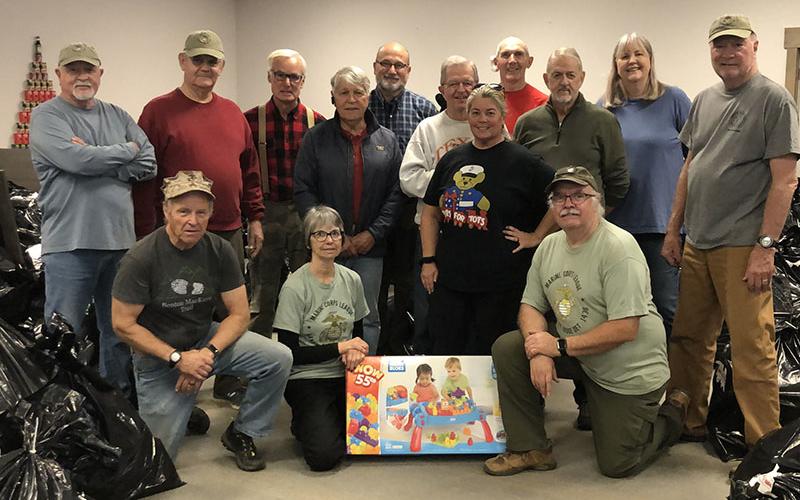 Surrounded by bags of toys that were distributed during the 2021 Toys for Tots program are volunteers, from left, front, Andy Meeks, Sherri Roberts and Bruce Van Do Gohn; back, Thom Potito, Ron Wilkander, Dick Evelyn, Joel Warner, Erik Youngberg, Jim Brumbelow, Coordinator Cheryl Jordan, Ian Guttridge, Chuck Clark, Gale Mancuso and Dale Greene.