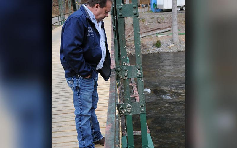 Fannin County Public Works Director Zack Ratcliff inspects repairs to a gusset plate on Shallowford Bridge. Those repairs included painting the work area, part of which lies below the main steel beam and is not visible.