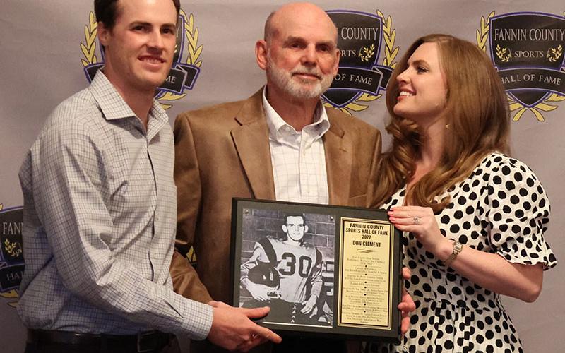 Inductee Don Clement, middle, accepted his plaque with his son Landon, left, and his daughter Leia, right, at the Sports Hall of Fame Ceremony April 9.