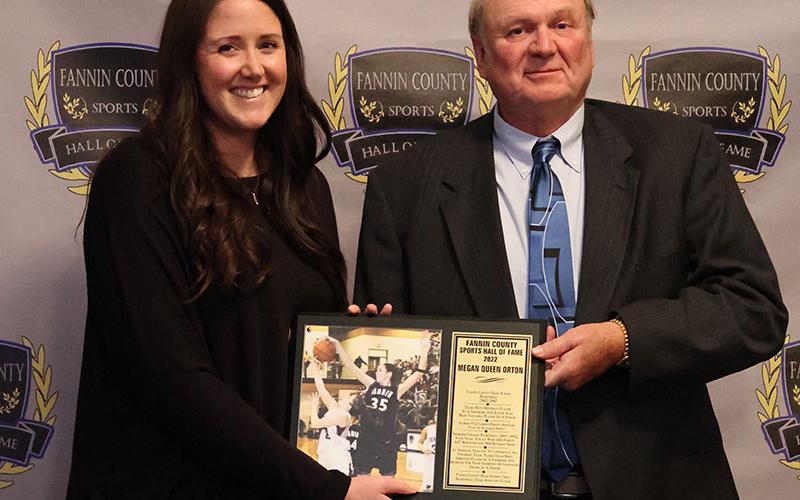 Inductee Megan Queen Orton, left, receives her plaque from Coach Johnny Farmer, right, at the Sports Hall of Fame ceremony April 9.