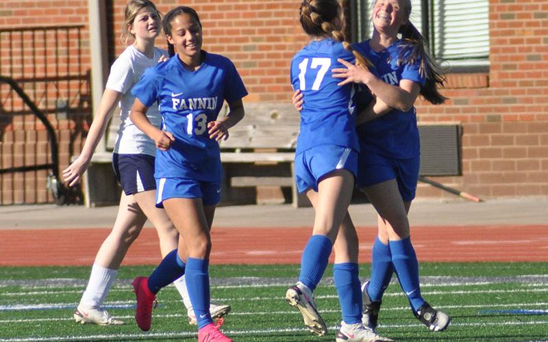 Lady Rebel Emma Richardson smiles wide and celebrates with teammate Cali Tuggle (#17) and Stephanie Kirk (#13) after scoring a goal against Haralson County Thursday, April 14. The Lady Rebels won the game 9-0 and will continue to the second round of the state playoffs Wednesday, April 20.