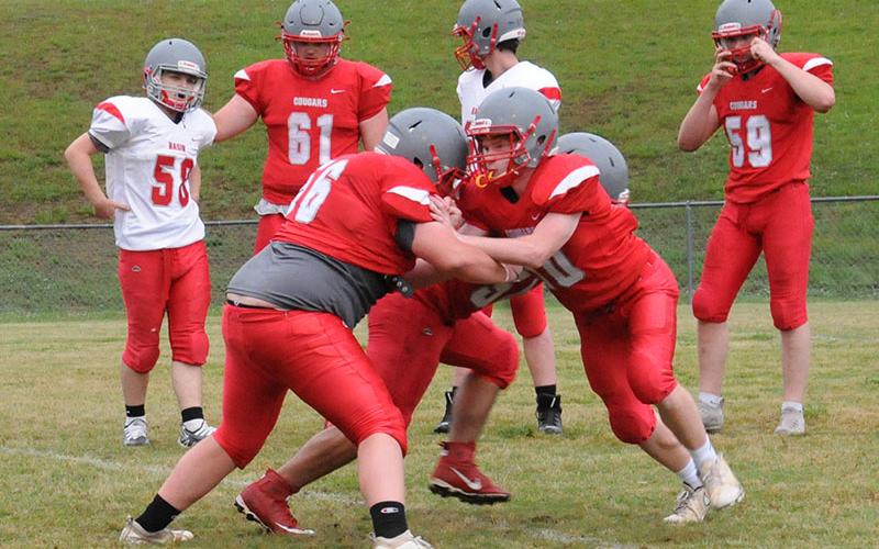 Isaac Henderson (56) works against Kelle Shroth (10) in a blocking drill as the Copper Basin High School Cougars warned up for their Spring Showcase in front of fans last Thursday. Among players waiting their turn to get in on the action are Josh Burkett (58), Addison Hook (61).