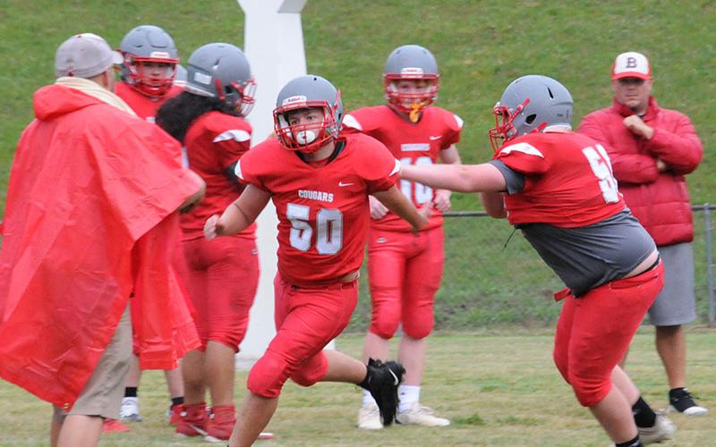 Zach Beach (50) gets around Isaac Henderson (56) as the Copper Basin Cougars warmed up for their Spring Showcase Thursday night, May 26, in front of fans at the high school football field.
