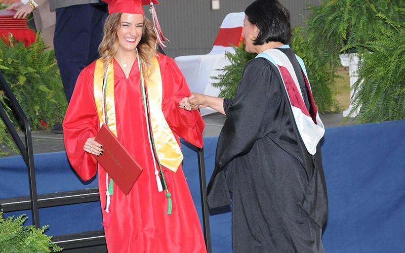 Copper Basin High School graduate Maleia Bigham receives a congratulatory fist bump from Zulma Youngs after receiving her diploma Friday night at Copper Basin. For more coverage from the event, please see page A4.