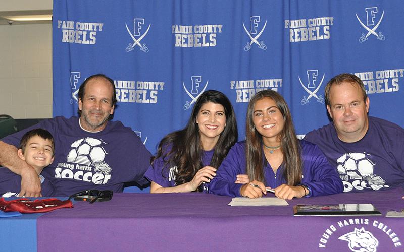 Taylor Poland smiles after signing her letter of intent to play soccer at Young Harris College. Shown are, from left, Levi, Carl and Rebecca Weinzierl, Poland and Ronnie Poland.