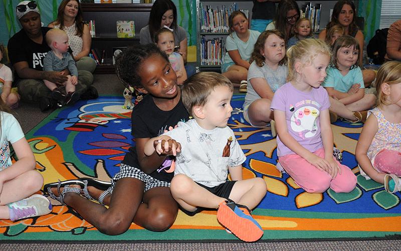 Youngsters paid close attention to Hannah Loudermilk (not shown) as summer programs kicked off at the Fannin County Public Library last week. Numerous events are planned throughout the end of July.