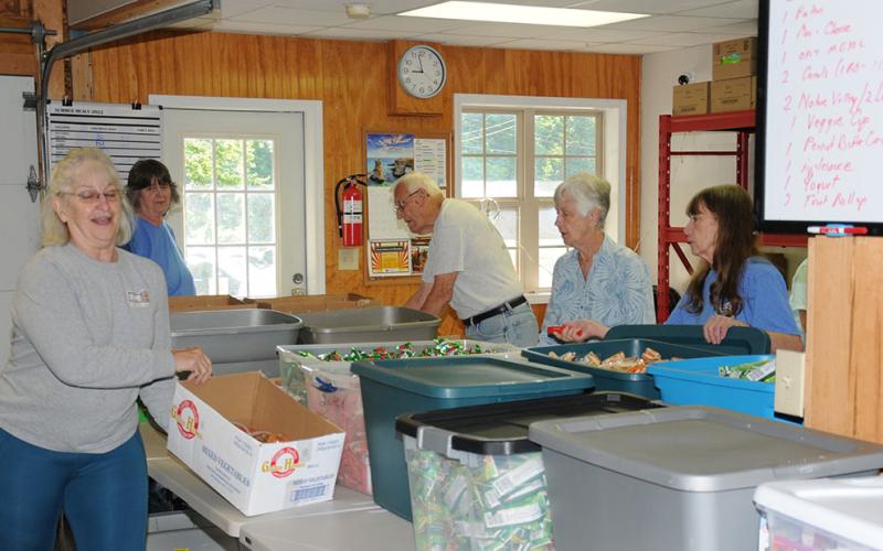 The Summer Meal Program Prep Crew was busy last week getting everything in order for 750 bags filled with meals for children to be packed. Another 160 family meal bags would also be prepared. The crew includes, from left, Kathleen Holt, Vicki Smith, Dave Tickner, Kathleen Tickner and Barbara Davenport.
