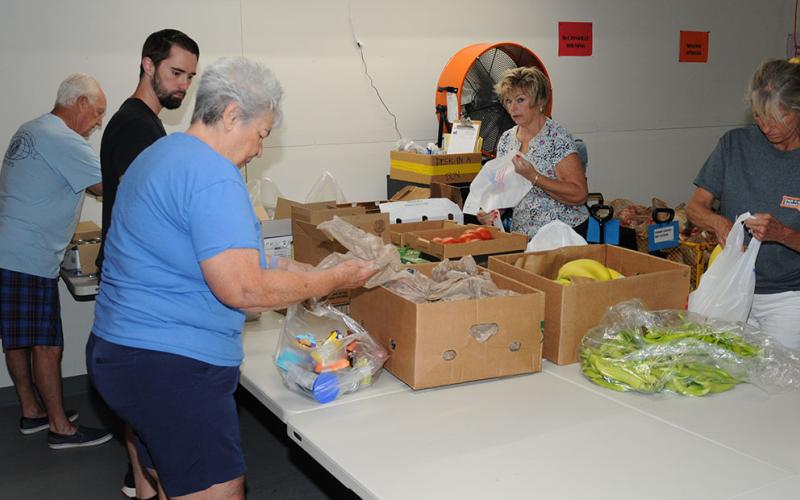 aThe Fresh Produce and Family Meal Packers of the Summer Food Program were all business last week as they went about their weekly volunteer effort. Members of this crew include, from left, Bill Echelberger, Zac Meaders, Ann Brayley, Carol Ross and Sherry Echelberger. They are part of the summer volunteer team that packs 750 bags for children and 160 for families every week. The packing is more than double what Snack in a Backpack does every week during the school year.