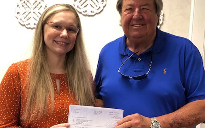 Tammy Grindstaff of United Community Bank presents the bank’s donation for Fire in the Sky to Lake Blue Ridge Civic Association representative Rick Glueckert.