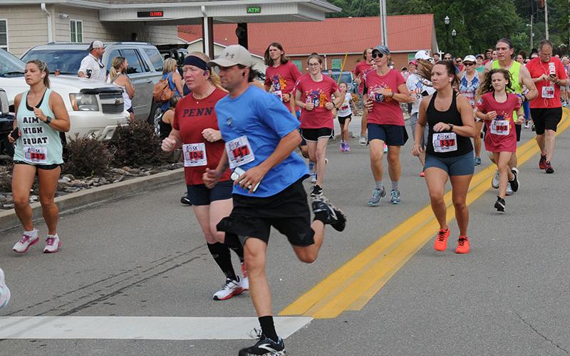Runners turn the corner on to Blue Ridge Drive as they begin the Walk the Line 5K in McCaysville Saturday evening, July 2. The event is part of the Riverwalk Run Series that features a course covering two states and crossing two bridges. The run kicked off Saturday evening festivities that included a fireworks show from Tater Hill in McCaysville and live music at Tooney’s Music Venue.