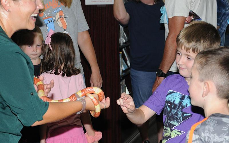 Kathy Church of Smithgall Woods State Park near Helen, Georgia, returned to the Fannin County Public Library last week, this time for a Creepy Crawler presentation. While most of her presentation focused on various bugs and spiders, she brought along one snake for children to pet. She reminded children when they see such ‘crawlers,’ “don’t touch.” This young man was being extremely careful before petting the snake.