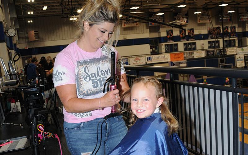 Callie Mayfield has her hair cut and styled by Susan Patterson during the Summer Bash. Patterson was one of several hair stylists who donated their time for the event.