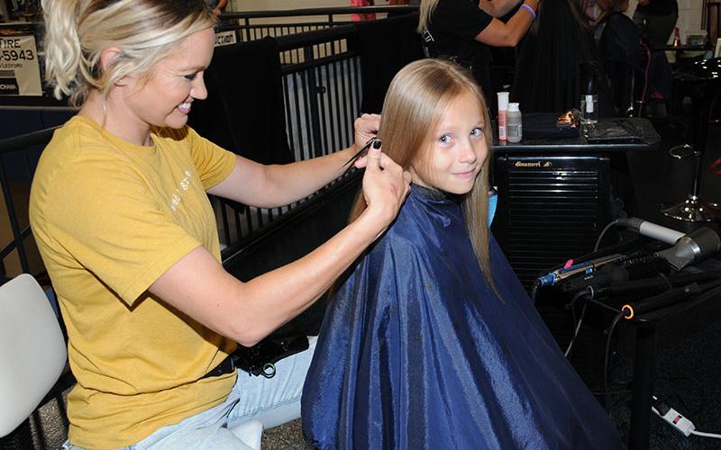 Celeste Lance styles Oliva Roesch’s hair during the Summer Bash at Fannin County High School Saturday, July 9. The event started with a conversation between Lance and the school system’s licensed clinical social worker, Sheena Rymer. Lance was one of several hair stylists who donated their time Saturday.