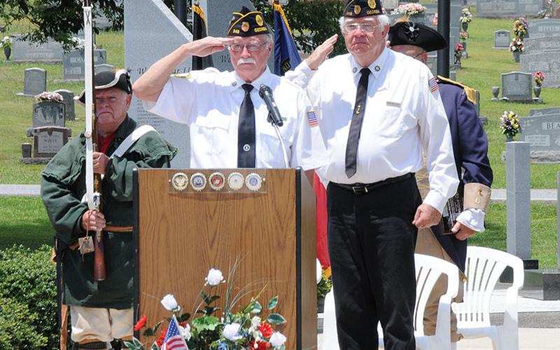 Bil Stodghill, left, and Ron Wallace salute during the retiring of the colors at the Independence Day celebration.