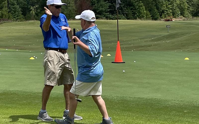 Special Olympics Golf Coach and Coordinator Craig Hartman, left, cheers for athlete Jay Jenkins, right, at Old Toccoa Farm Tuesday, July 19.