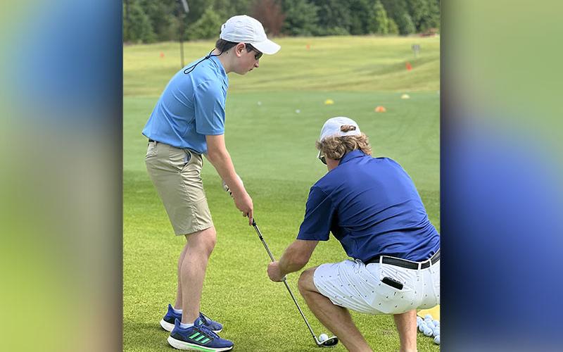 Special Olympic Athlete Alex Hughes, left, lines up his shot with the help of Steve Demboski, right, at the Special Olympics golf event Tuesday, July 19 at Old Toccoa Farm. Hughes ended the day in first place with the top score.