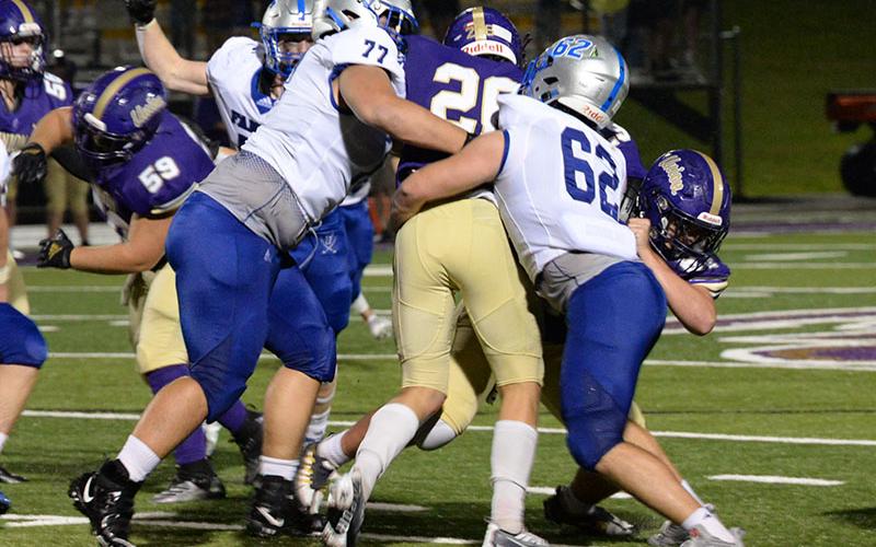 Fannin County defensive linemen Logan Long (77) and Case Holloway (62) find the ball and wrap up the Union County ball carrier in the game against Union County Friday, August 19.
