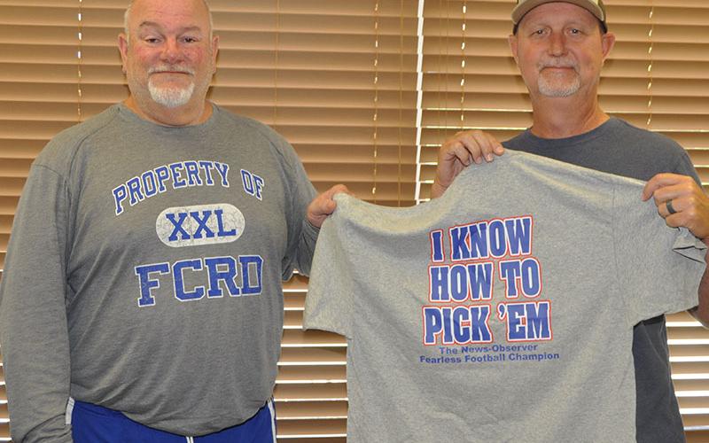 John Spargo, left, awards last year’s Fearless Football Forecaster champion Eddie O’Neal, right, with the championship t-shirt.