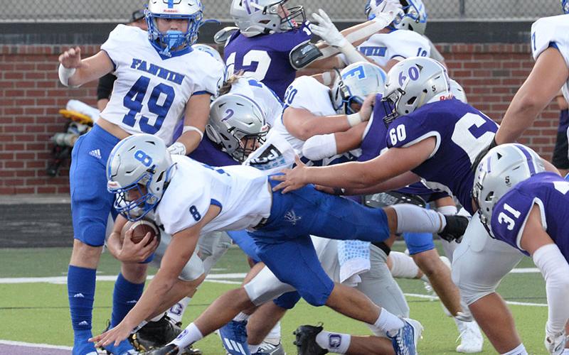 Corbin Davenport (8) dives through the line for a Rebel touchdown while Cade Sands (49) and Jacob Dye (60) block for him during the game against the Bobcats at Gilmer County Friday, August 26.