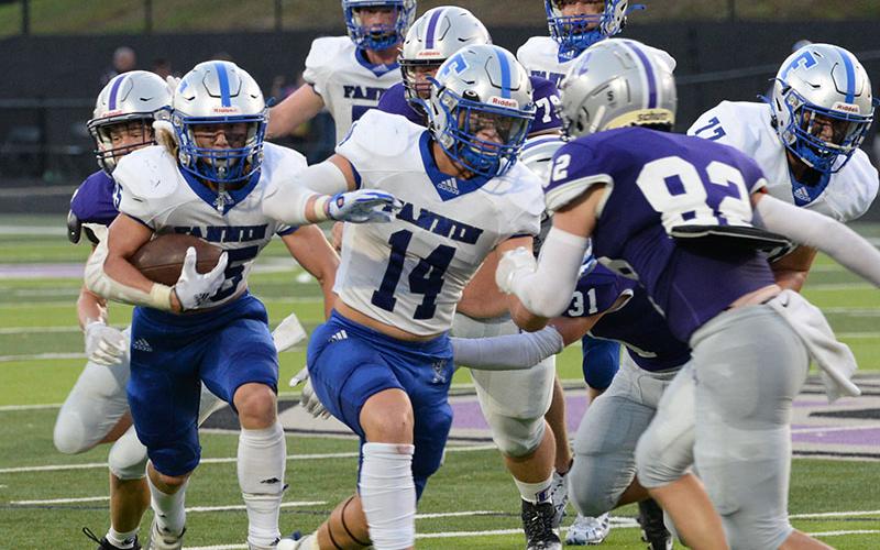Carson Callihan, left, carries the ball up the field for the Rebels while Cooper Born (14), right, clears a path for him during the game against Gilmer County Friday, August 26.